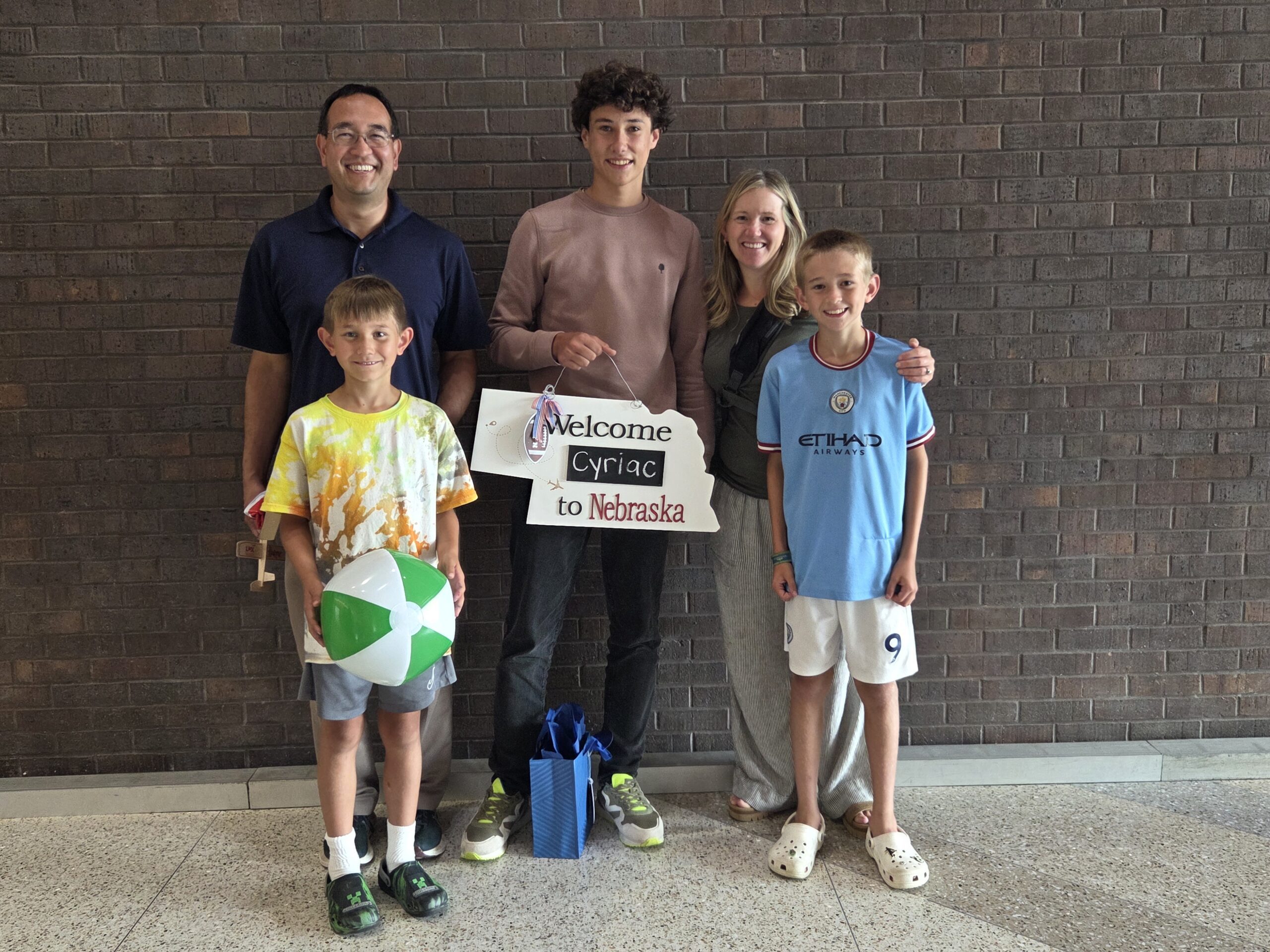 Cyriac from France poses with his host family at the airport.