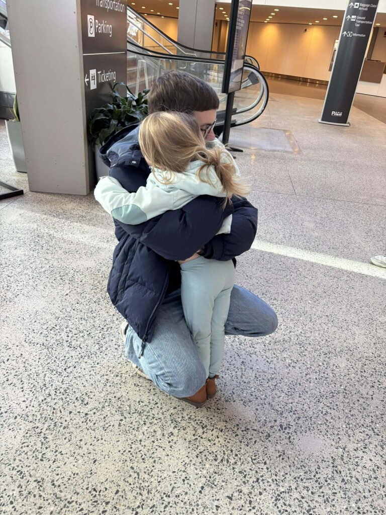 At the airport before his return to Germany, Max hugs his host sister, Sophia goodbye.